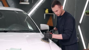 Adam garajda araba cilalıyor.