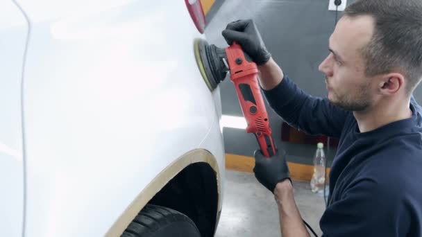 Homme polir une voiture dans un garage — Video