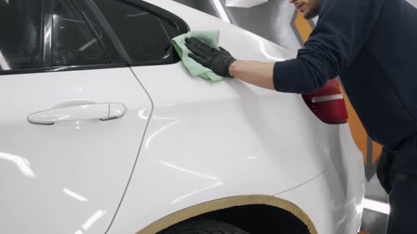 Hombre pulir un coche en un garaje — Vídeos de Stock