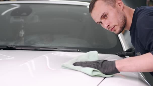 Uomo lucidare una macchina in un garage — Video Stock