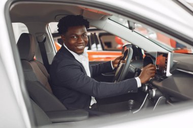 Yakışıklı ve zarif bir siyah adam bir araba salonunda.