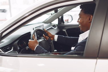 Yakışıklı ve zarif bir siyah adam bir araba salonunda.