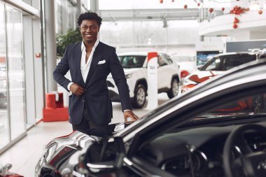 Yakışıklı ve zarif bir siyah adam bir araba salonunda.