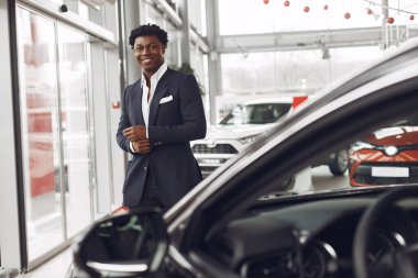 Yakışıklı ve zarif bir siyah adam bir araba salonunda.