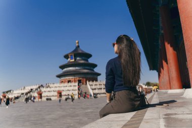 Esmer kız Çin 'deki Heven tapınağının merdivenlerinde oturuyor.