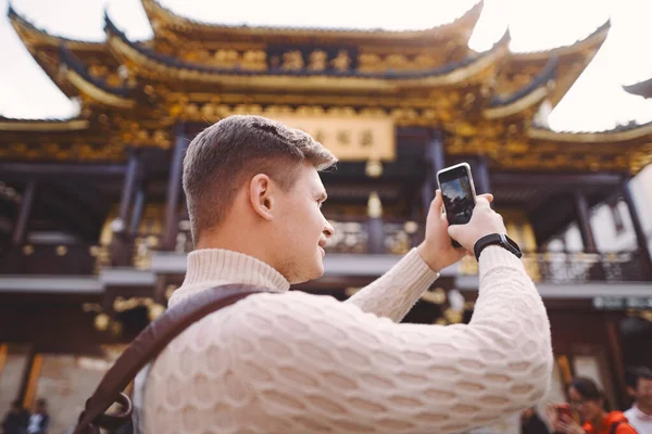 Male tourist taking photos of a pagoda at Yuyuan market in Shanghai — Stock Photo, Image