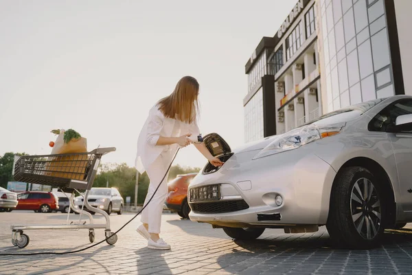 Wanita pengisian mobil elektro di pompa bensin listrik — Stok Foto