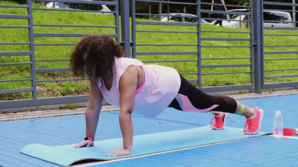 Over de grootte van een vrouw die stretching oefeningen doet — Stockvideo