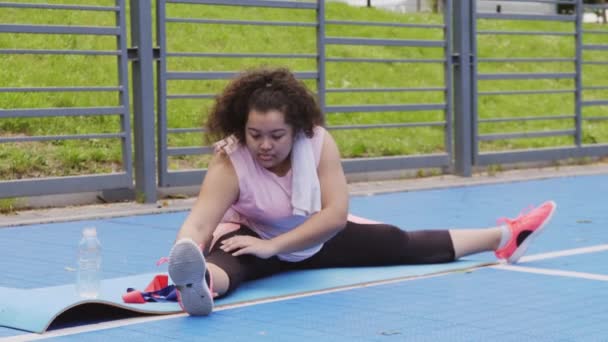 Над размером женщины, делающей упражнения на растяжку — стоковое видео