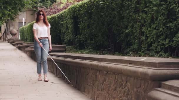 Joven ciego con bastón largo caminando en una ciudad — Vídeo de stock