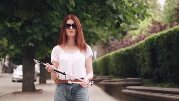 Young blind person with long cane walking in a city — Stock Video