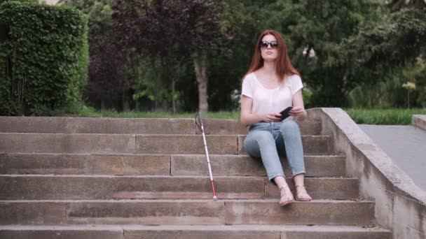 Ung blind person med lång käpp promenader i en stad — Stockvideo