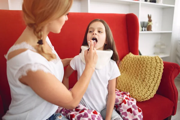 Mutter gibt ihrer kranken Tochter Kehlkopfmedizin — Stockfoto