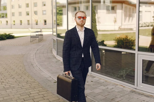 Επιχειρηματίας με βαλίτσα περπατώντας σε μια καλοκαιρινή πόλη — Φωτογραφία Αρχείου
