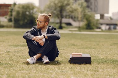 Kitaplı bir iş adamı bir yaz şehrinde oturuyor.