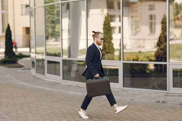Geschäftsmann mit Koffer spaziert in Sommerstadt — Stockfoto