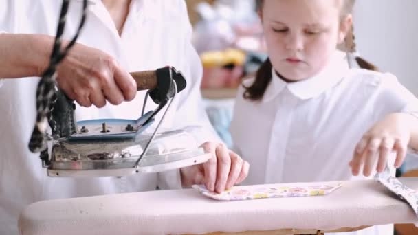 Oma met kleine kleindochter ijzeren kleren in de fabriek — Stockvideo