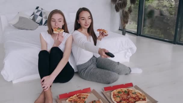 Girls friends eats pizza and watching TV at home — Stock Video