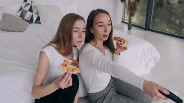 Meninas amigos come pizza e assistindo TV em casa — Vídeo de Stock