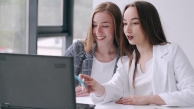 Ofiste dizüstü bilgisayarı olan iki kadın.