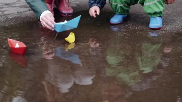 Забавный парень в дождевых сапогах играет в парке — стоковое видео