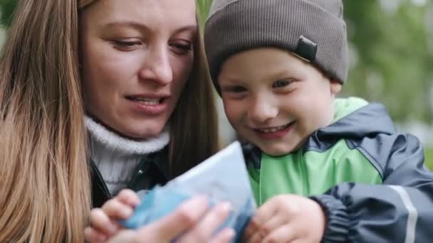 Grappig kind in regenlaarzen spelend in een regenpark — Stockvideo