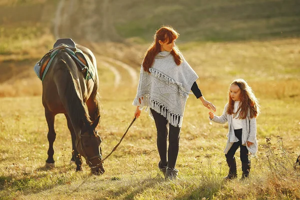 母亲和女儿在田野里和马玩耍 — 图库照片