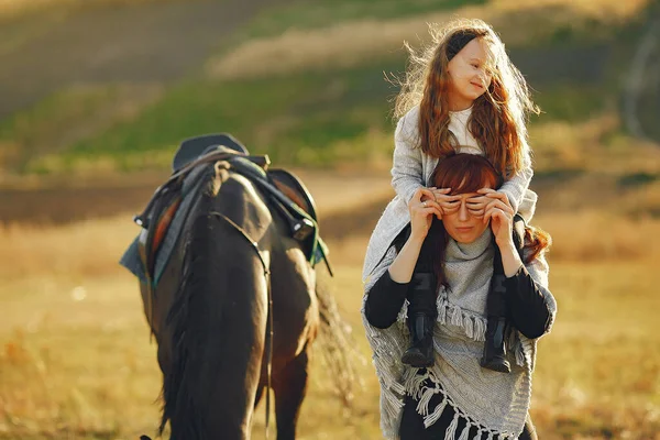 Matka i córka na polu gry z koniem — Zdjęcie stockowe
