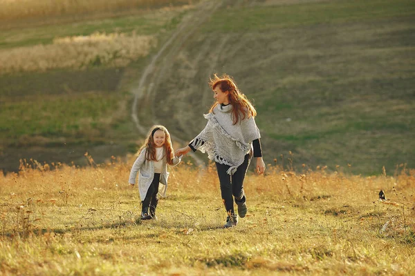 Madre con figlioletta che gioca in un campo autunnale — Foto Stock
