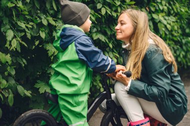 Yağmur parkında oynayan çizmeli komik çocuk.