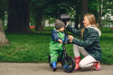 Yağmur parkında oynayan çizmeli komik çocuk.