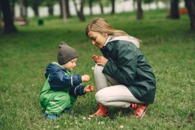 Yağmur parkında oynayan çizmeli komik çocuk.