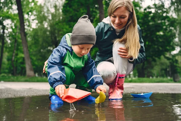 Lucu anak dalam sepatu bot hujan bermain di taman hujan — Stok Foto