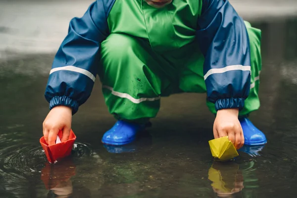 Lustiges Kind in Regenstiefeln spielt im Regenpark — Stockfoto