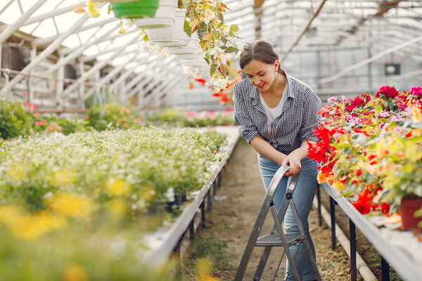 Woman in a blue shirt working in a greenhouse