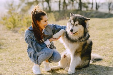 Köpeğiyle bahar tarlasında şık bir kız.