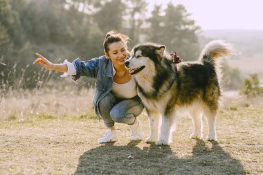 Köpeğiyle bahar tarlasında şık bir kız.