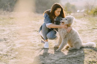 Köpeğiyle bahar tarlasında şık bir kız.
