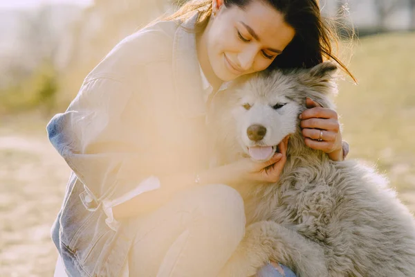 Köpeğiyle bahar tarlasında şık bir kız. — Stok fotoğraf