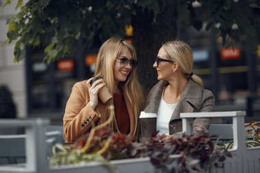 Yaz şehrinde oturan ve kahve içen bir kadın.