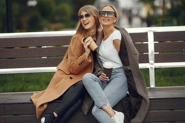 Ragazze sedute in una sity primavera e tenere il caffè in mano — Foto Stock