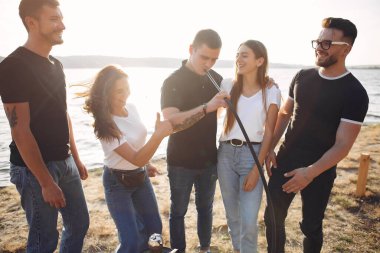 Gençler dışarıda nargile içerek pizza yiyor.