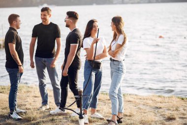 Gençler dışarıda nargile içerek pizza yiyor.