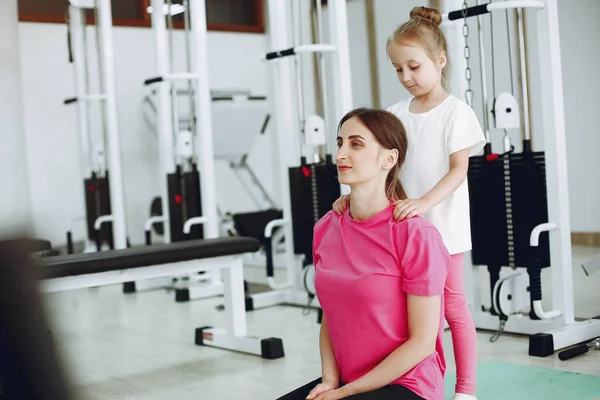 Mãe com pequena filha está envolvida em ginástica no ginásio — Fotografia de Stock