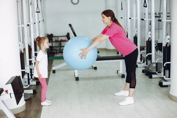 Mother with little daughter are engaged in gymnastics in the gym — Stock Photo, Image