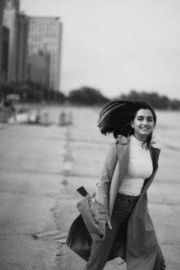 Genç kız sahilde yürüyor.