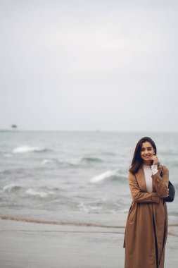 Genç kız sahilde yürüyor.