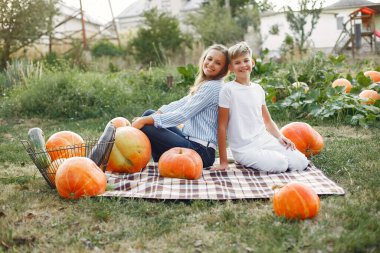 Anne ve oğlu balkabaklarının yakınındaki bir bahçede oturuyor.