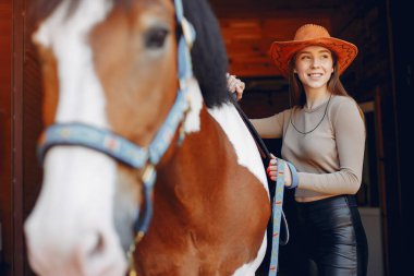 Güzel bir kadın atıyla ayakta duruyor