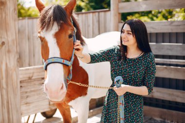 Güzel bir kadın atıyla ayakta duruyor